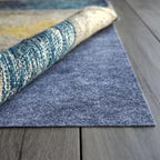Roll of blue textured rug on a wooden floor